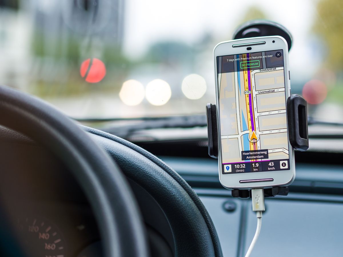 Smartphone in a car phone holder showing navigation